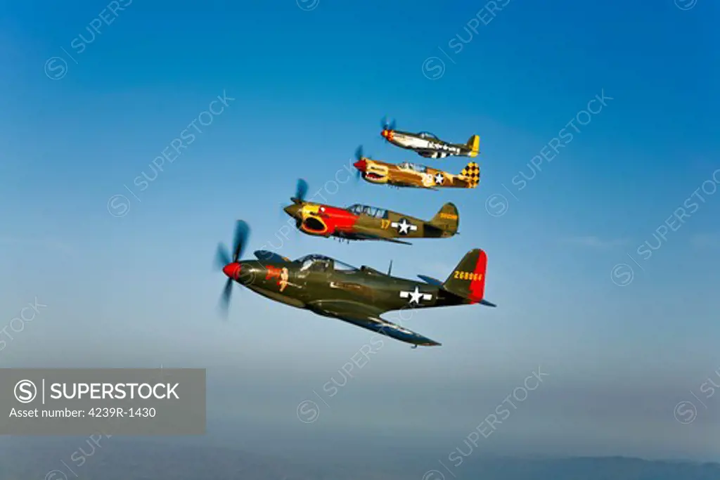 A Bell P-63 Kingcobra, two Curtiss P-40N Warhawk, and a North American P-51D Mustang in flight near Chino, California