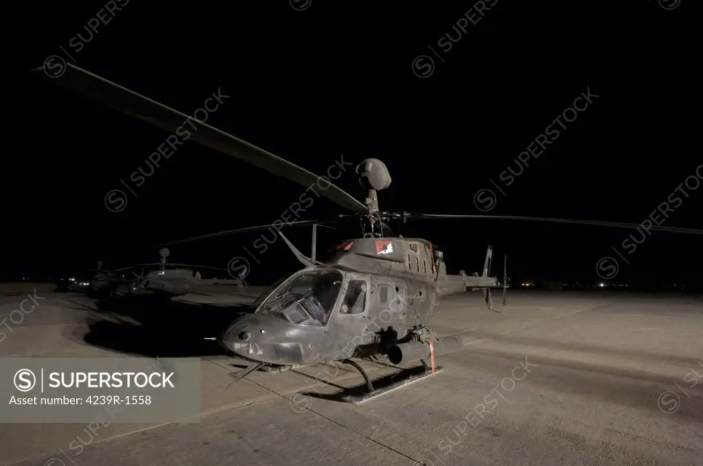Tikrit, Iraq - An OH-58D Kiowa sits on its pad at night