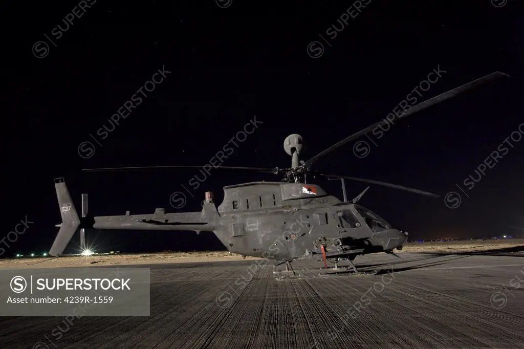 Tikrit, Iraq - An OH-58D Kiowa sits on its pad at night