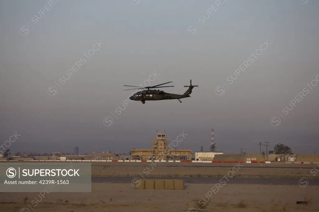 Tikrit, Iraq - A UH-60 Blackhawk helicopter flies past the tower on Camp Speicher
