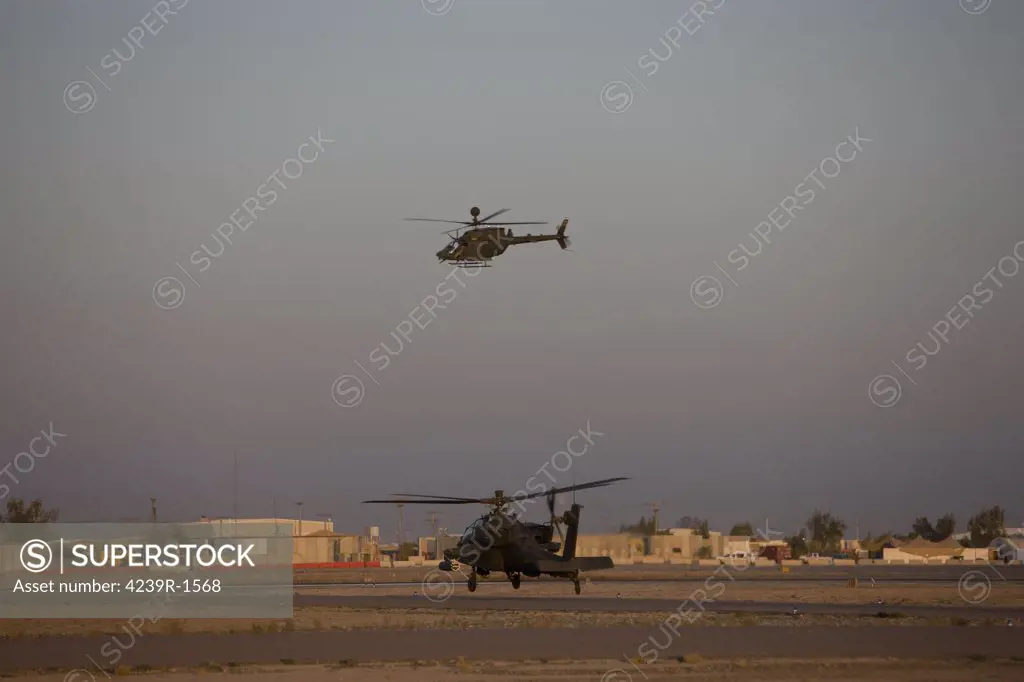 Tikrit, Iraq - An AH-64D Apache Longbow Block III attack helicopter waits for an OH-58 Kiowa to clear his flight space
