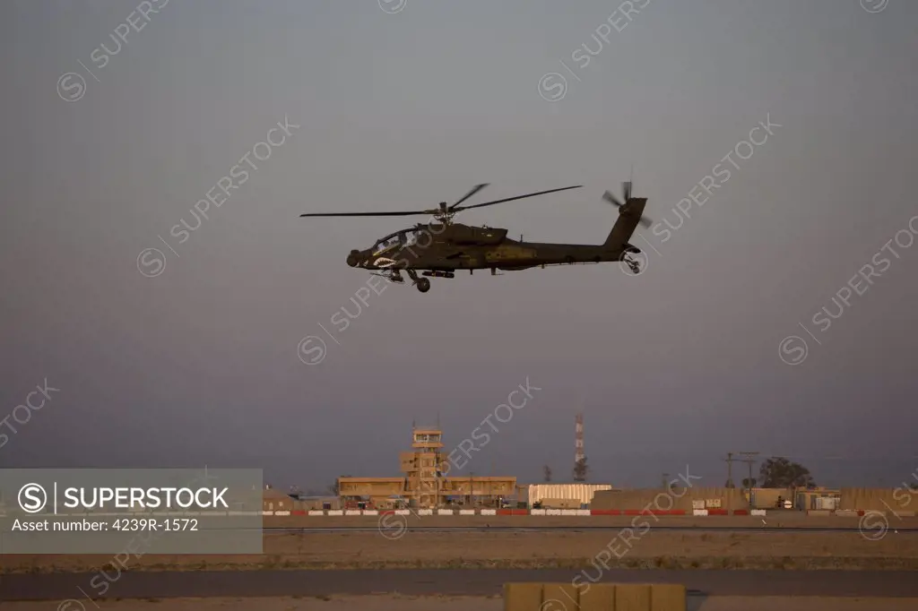 Tikrit, Iraq - An AH-64D Apache Longbow Block III attack helicopter flies by the control tower on Camp Speicher