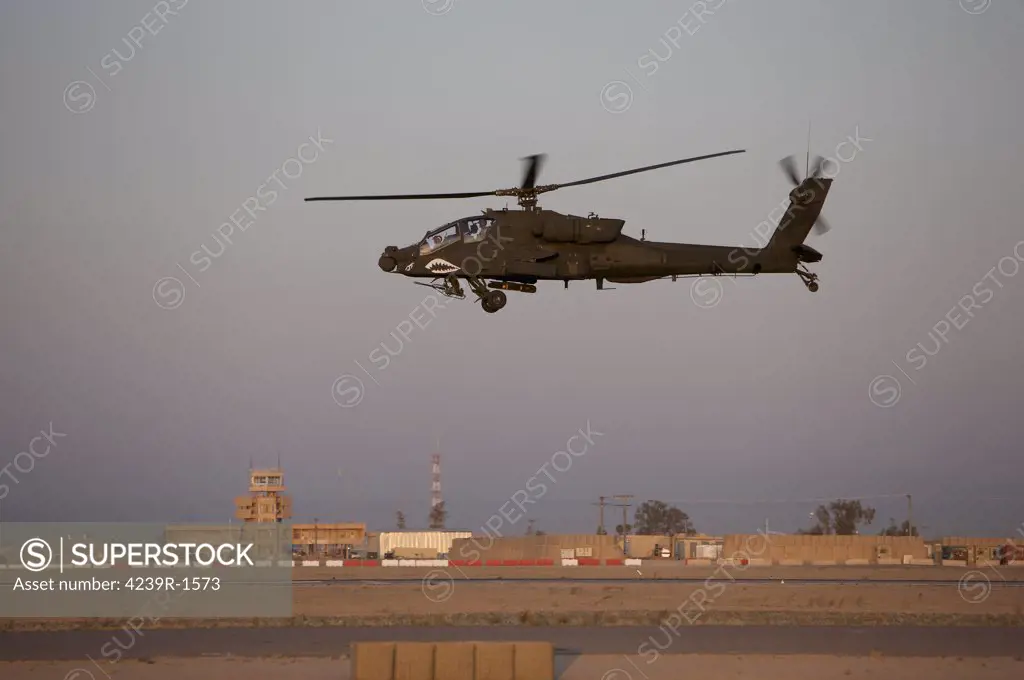 Tikrit, Iraq - An AH-64D Apache Longbow Block III attack helicopter flies by the control tower on Camp Speicher