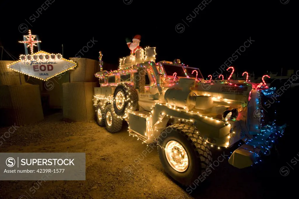 Cougar Mine Resistant Ambush Protected Vehicle (MRAP) is adorned in holiday lights parked in front of EOD Iraq