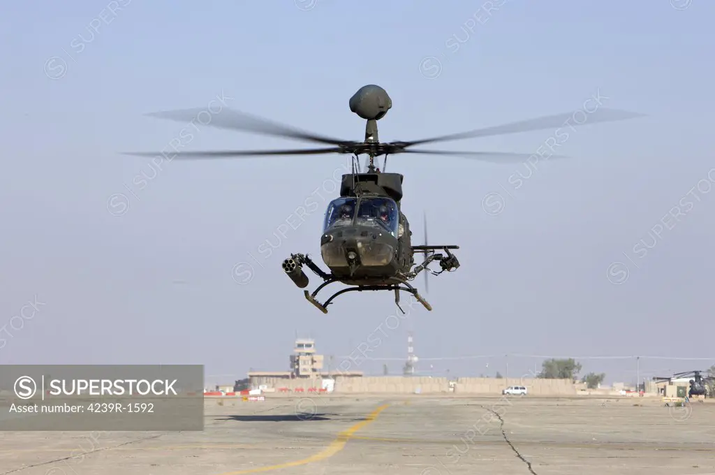 An OH-58D Kiowa Warrior hovers over the flight line at Camp Speicher, Iraq