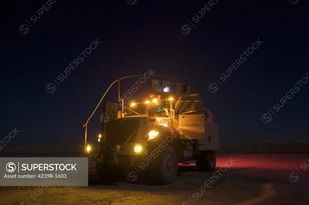 A MaxxPro Mine Resistant Ambush Protected (MRAP) vehicle with running lights on at night