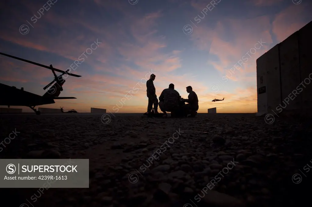 Tikrit, Iraq - A UH-60 Black Hawk crew carry out a mission brief at sunset