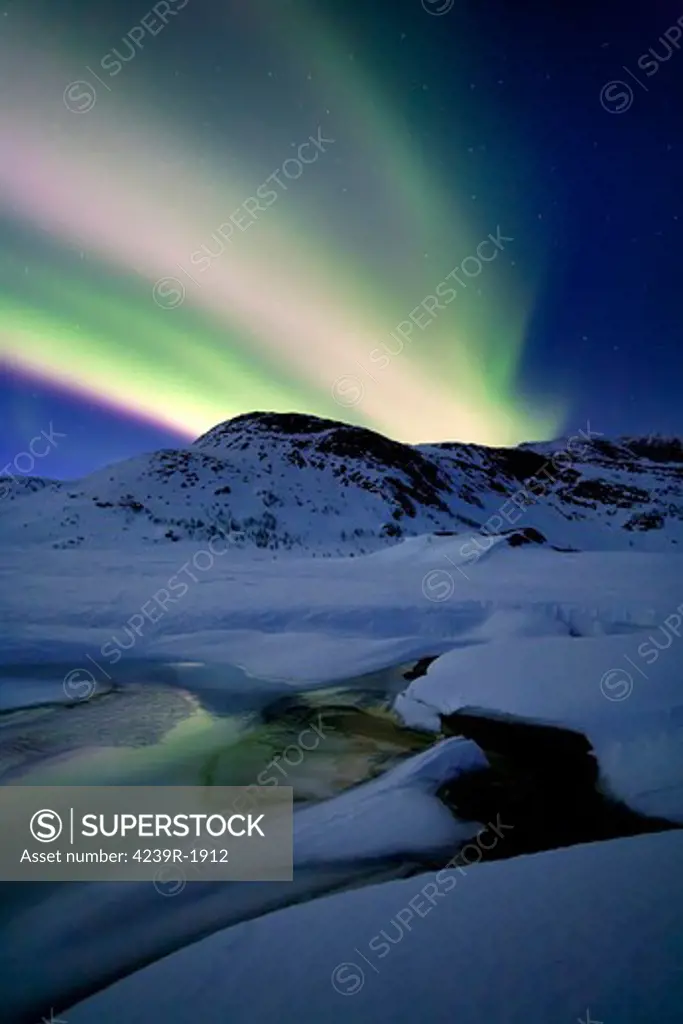 Aurora Borealis over Mikkelfjellet Mountain in Troms County, Norway. Auroras are the result of the emissions of photons in the Earth's upper atmosphere.