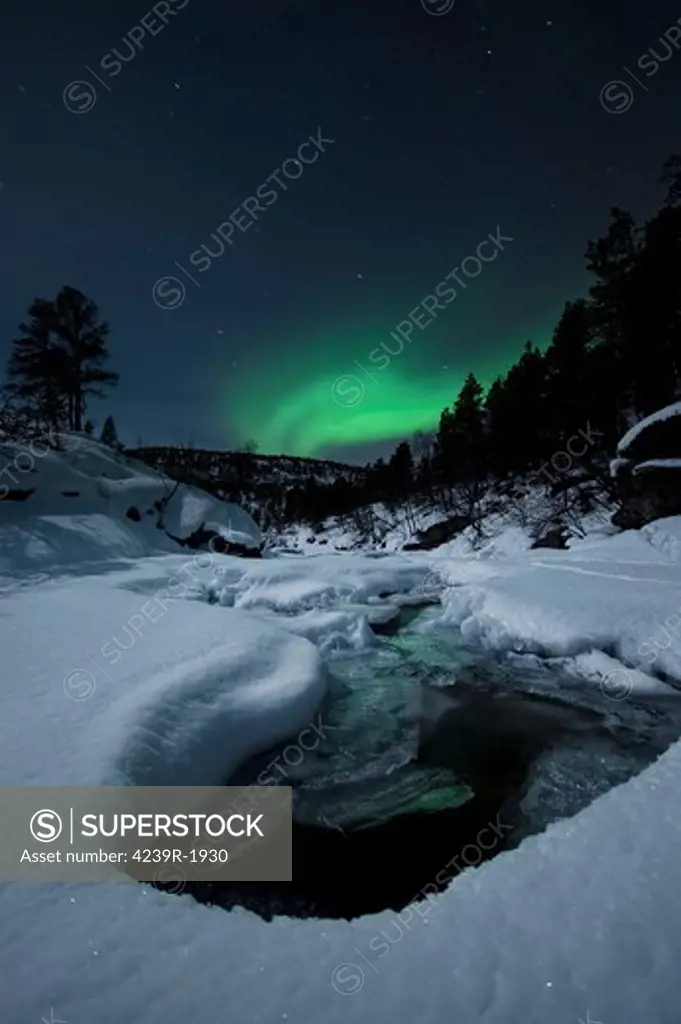 Aurora Borealis over Tennevik River in Norway. Auroras are the result of the emissions of photons in the Earth's upper atmosphere.