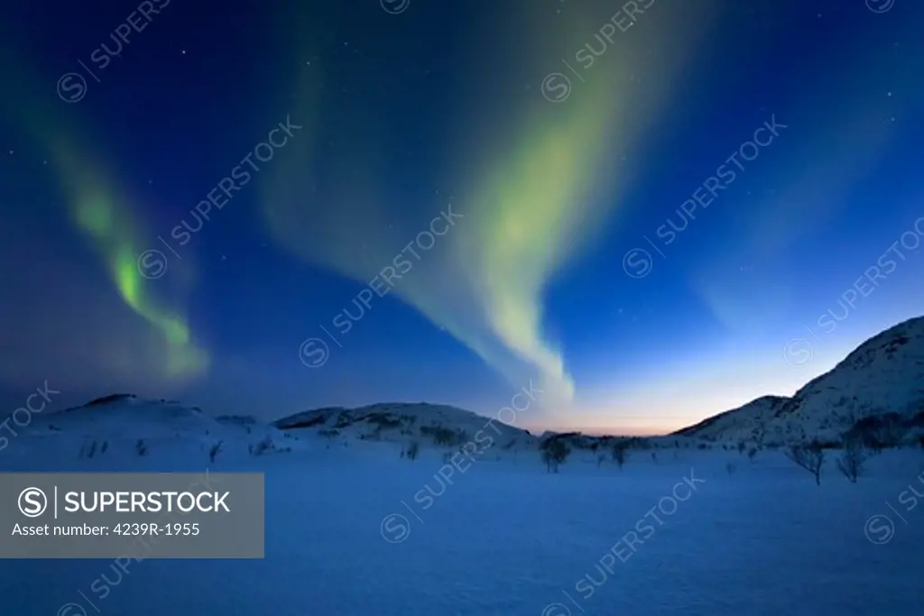 Aurora Borealis over Skittendalen Valley in Troms County, Norway. Auroras are the result of the emissions of photons in the Earth's upper atmosphere.