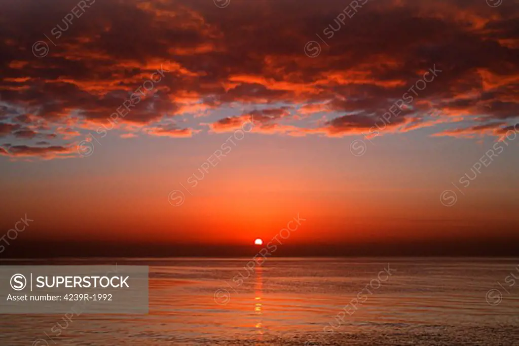 A layer of clouds is lit by the rising sun over Rio de la Plata, Buenos Aires, Argentina.