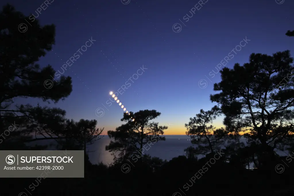 The Crescent Moon path seen during nautical twilight along with bright stars Spica and Porrima, and the planet Saturn, descend into the Atlantic Ocean in Fonte-da-Telha, Portugal.