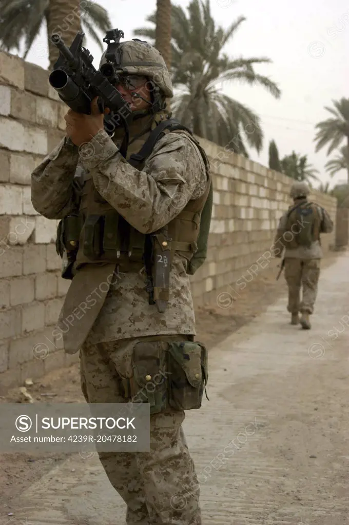 Ar Ramadi, Iraq, June 20, 2005 - A machine gunner uses his scope to get a better look at a position during a patrol through the city.