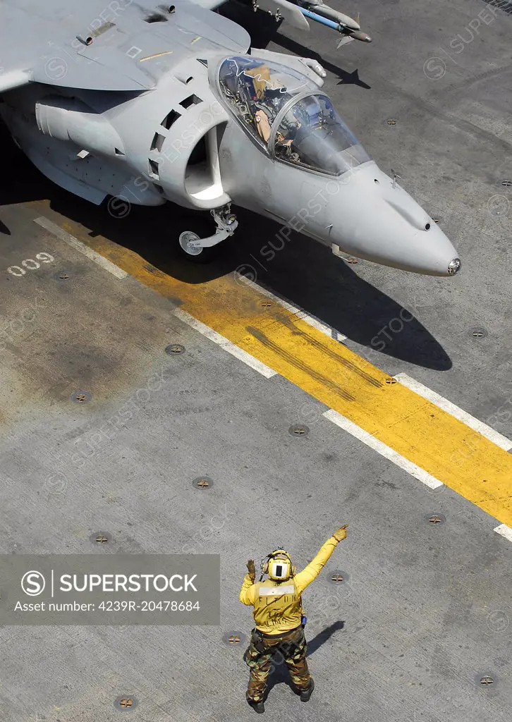 Pacific Ocean, May 15, 2008 - A Landing Signalman Enlisted uses hand signals to direct an AV-8B Harrier during flight operations aboard the amphibious assault ship USS Peleliu (LHA-5). 