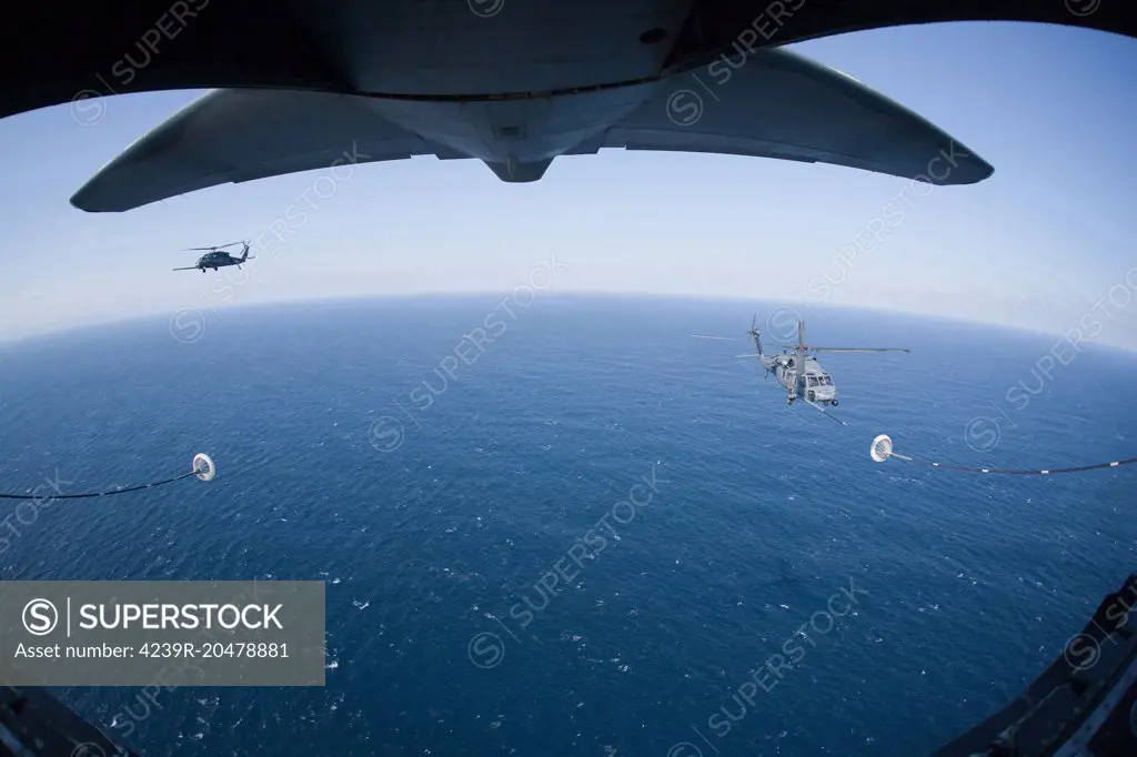 March 18, 2011 - An MC-130P Combat Shadow crew prepares to refuel two HH-60G Pave Hawk helicopters above the Pacific Ocean. 