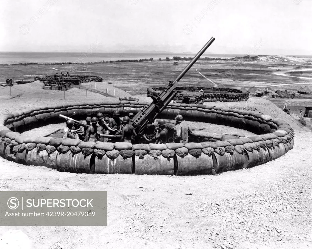 July 18, 1945 - View of a 90mm AAA gun emplacement with crew in pit, Okinawa, Japan.