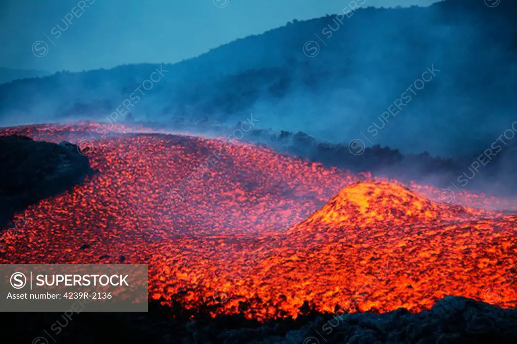 November 2006 - Boulder rolling in lava flow at dusk during eruption of Mount Etna volcano, Sicily, Italy.