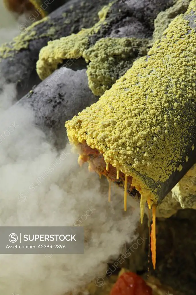 August 13, 2011 - Molten sulphur trickling out of condensation pipe, Kawah Ijen volcano, Java, Indonesia.