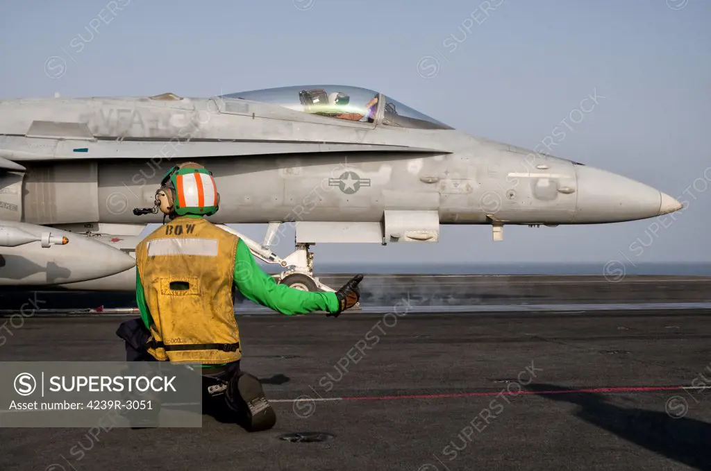 A shooter gives the thumbs up signal to launch an F/A-18C Hornet from the flight deck of USS Eisenhower. USS Eisenhower is operating in the 5th fleet area of responsibility off the coast of Pakistan.