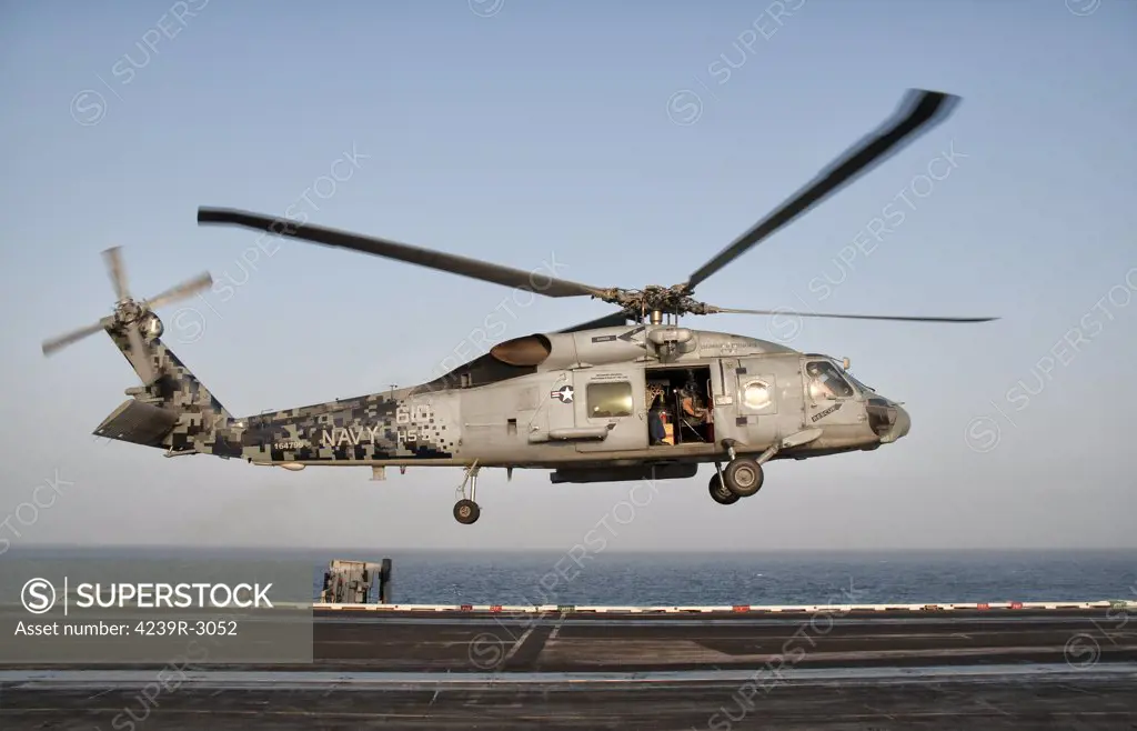 A US Navy SH-60F Seahawk hovers above the flight deck of USS Eisenhower. USS Eisenhower is operating in the 5th fleet area of responsibility off the coast of Pakistan.
