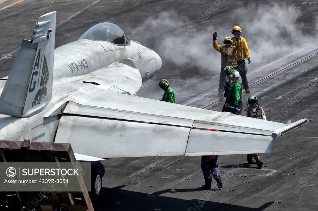 Flight deck crew position an F/A-18E Super Hornet into launch position aboard aircraft carrier USS Eisenhower. Eisenhower is operating in the 5th fleet area of responsibility off the coast of Pakistan.