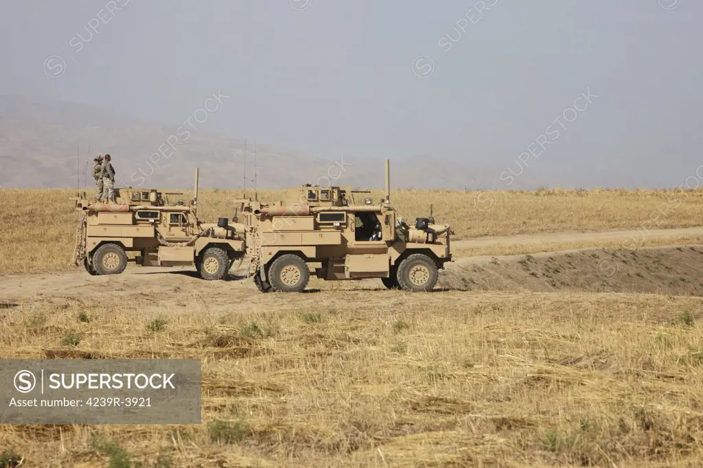 A pair of U.S. Army Cougar MRAP vehicles parked overlooking the top of a wadi during a weapons Familiarisation shoot, Kunduz, Afghanistan.
