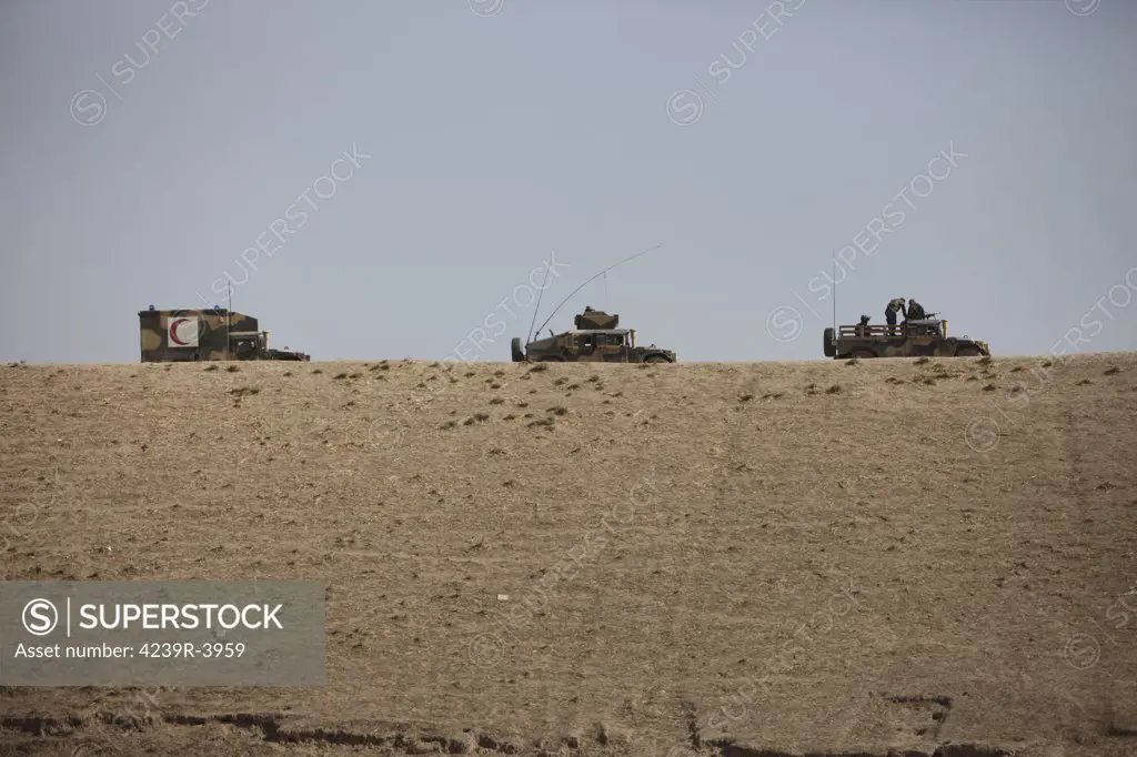 Afghan Army drives their HMMWV and HMMWV ambulance along the wadi ridge in Kunduz, Afghanistan.