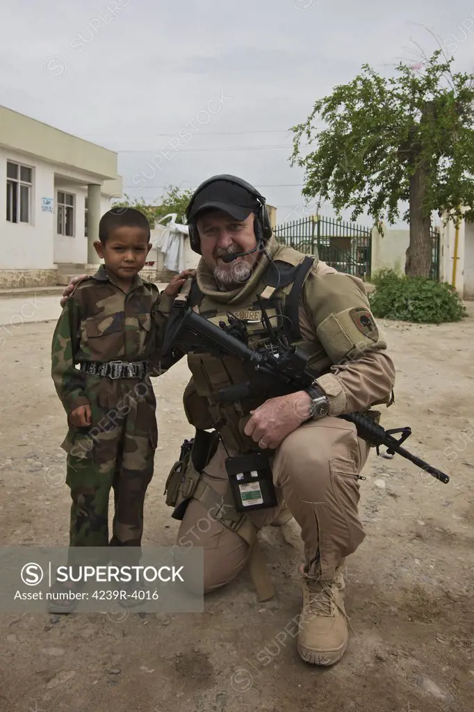 U.S. Contractor on a police mission in Northern Afghanistan poses for a picture with the Afghan Police Chief's son.