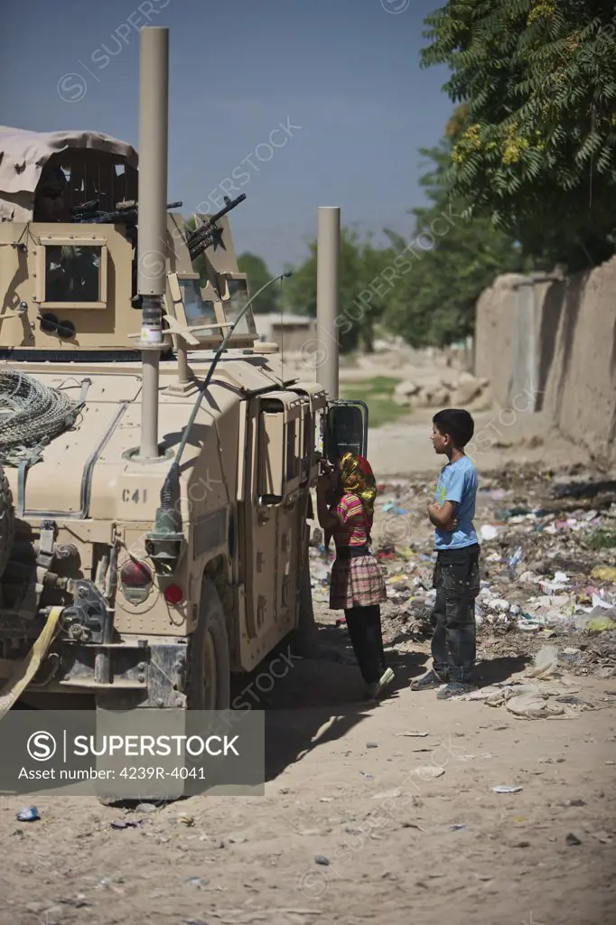Afghan children ask U.S. soldiers in their humvee for candy on the streets of Kunduz in Northern Afghanistan.