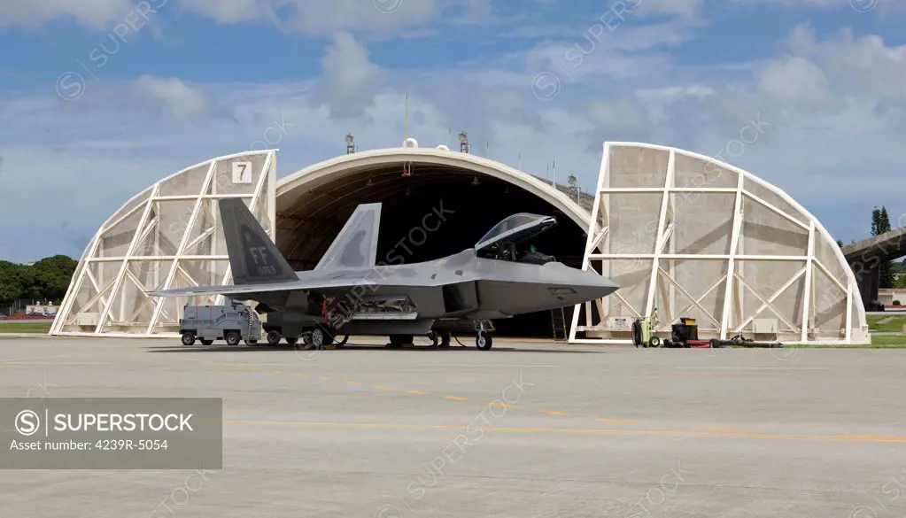 An F-22 Raptor from Langley Air Force Base, Virginia, sits in front of a hardened aircraft shelter at Kadena Air Base, Okinawa.