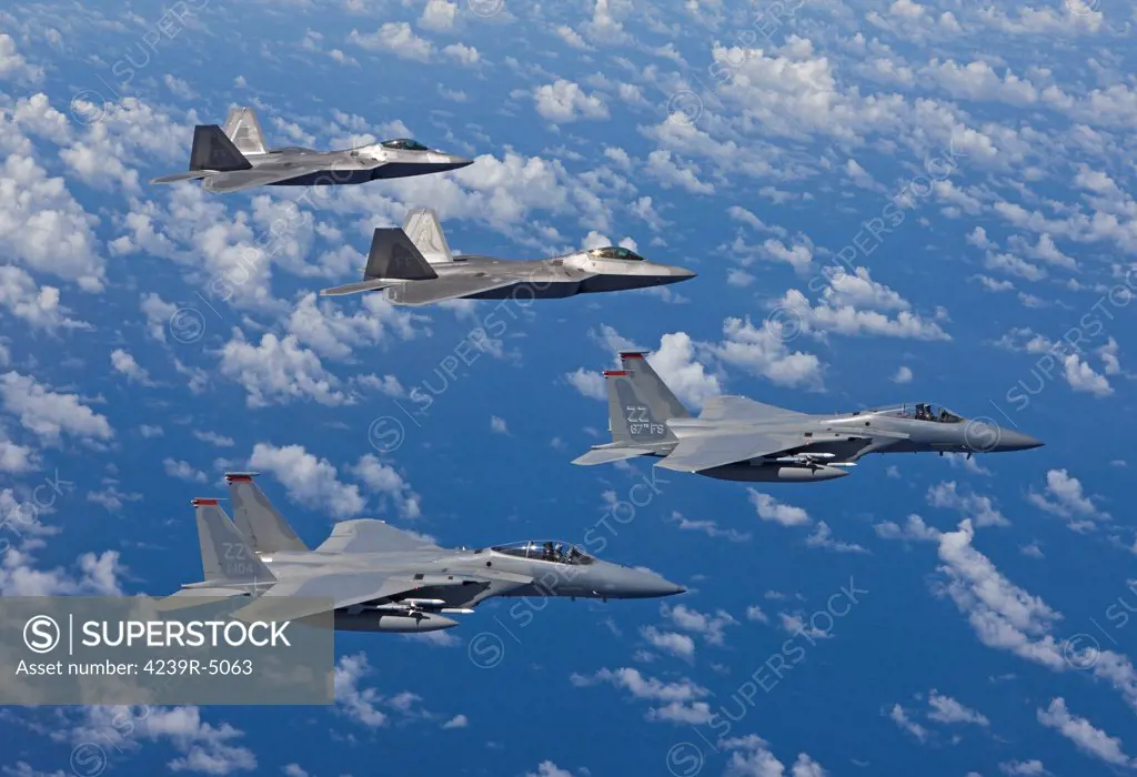 Two F-15 Eagles from the 67th Fighter Squadron in Kadena Air Base, Okinawa, Japan, fly over the Pacific Ocean in formation with two F-22 Raptors from Langley Air Force Base, Virginia, during a training mission.