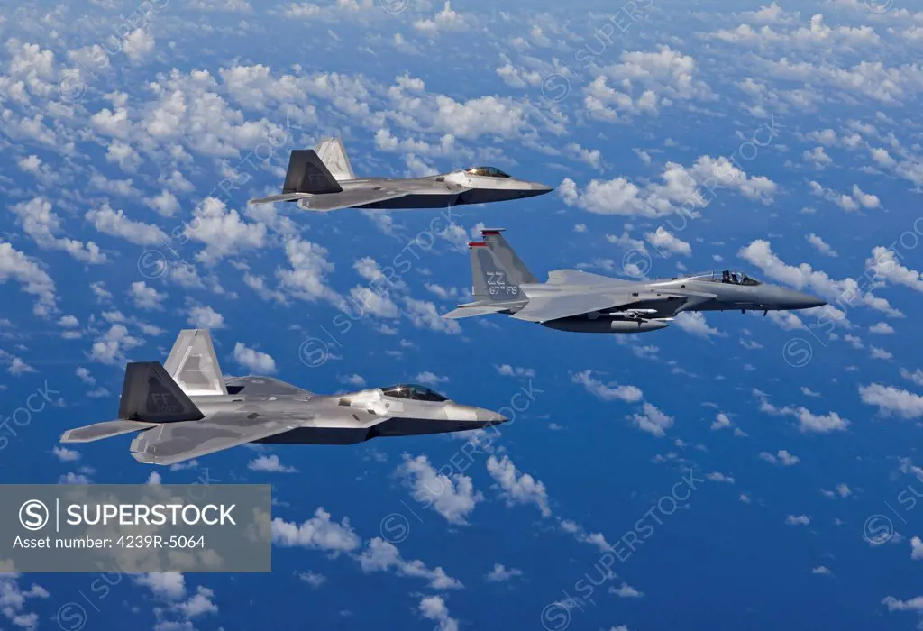 An F-15 Eagle from the 67th Fighter Squadron in Kadena Air Base, Okinawa, Japan, flies over the Pacific Ocean in formation with two F-22 Raptor's from Langley Air Force Base, Virginia, during a training mission.