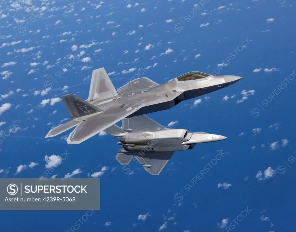 Two F-22 Raptors from the 1st Fighter Wing at Langley Air Force Base, Virginia, maneuver while flying a training mission out of Kadena Air Base, Okinawa, Japan.