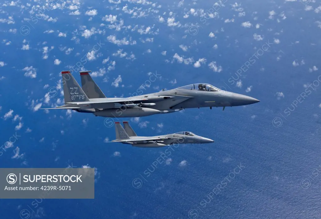 Two F-15 Eagles from the 18th Wing at Kadena Air Base, Okinawa, Japan, fly in formation over the Pacific Ocean.