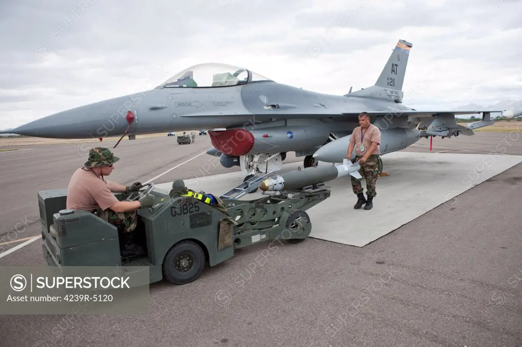 Weapons loaders from the 162nd Fighter Wing prepare to load a GBU-38 JDAM on an F-16 from the Air National Guard Air Force Reserve Test Center.