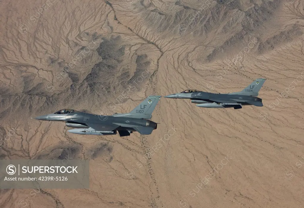 Two F-16's from the 56th Fighter Wing at Luke Air Force Base, Arizona, manuever on a training mission over the Arizona desert.