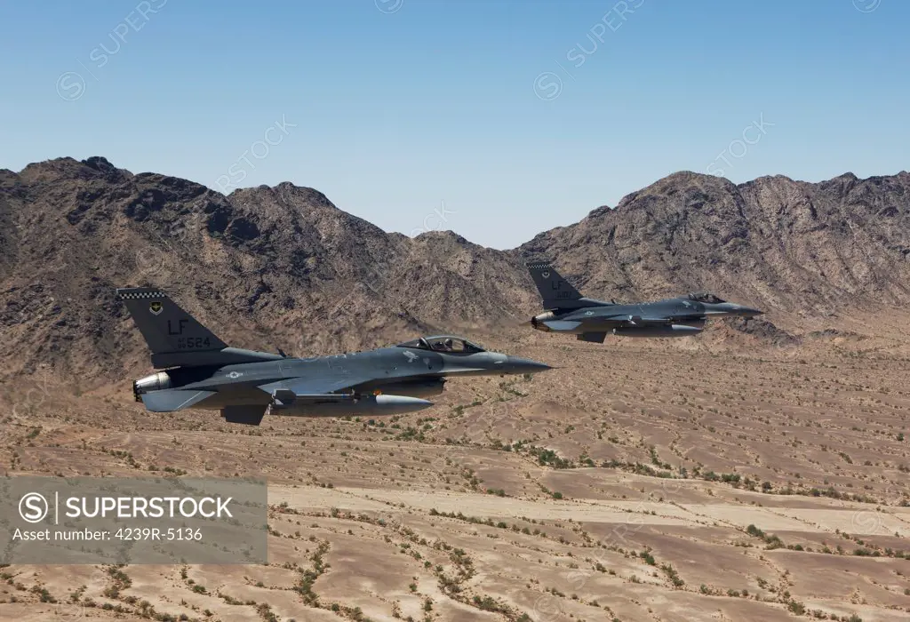 Two F-16's from the 56th Fighter Wing at Luke Air Force Base, Arizona, fly in formation while flying low level over the Arizona desert.