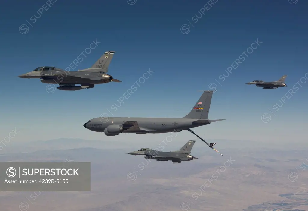 Three F-16's from the 56th Fighter Wing at Luke Air Force Base, Arizona, join up on a KC-135 on a training mission over the Arizona desert.