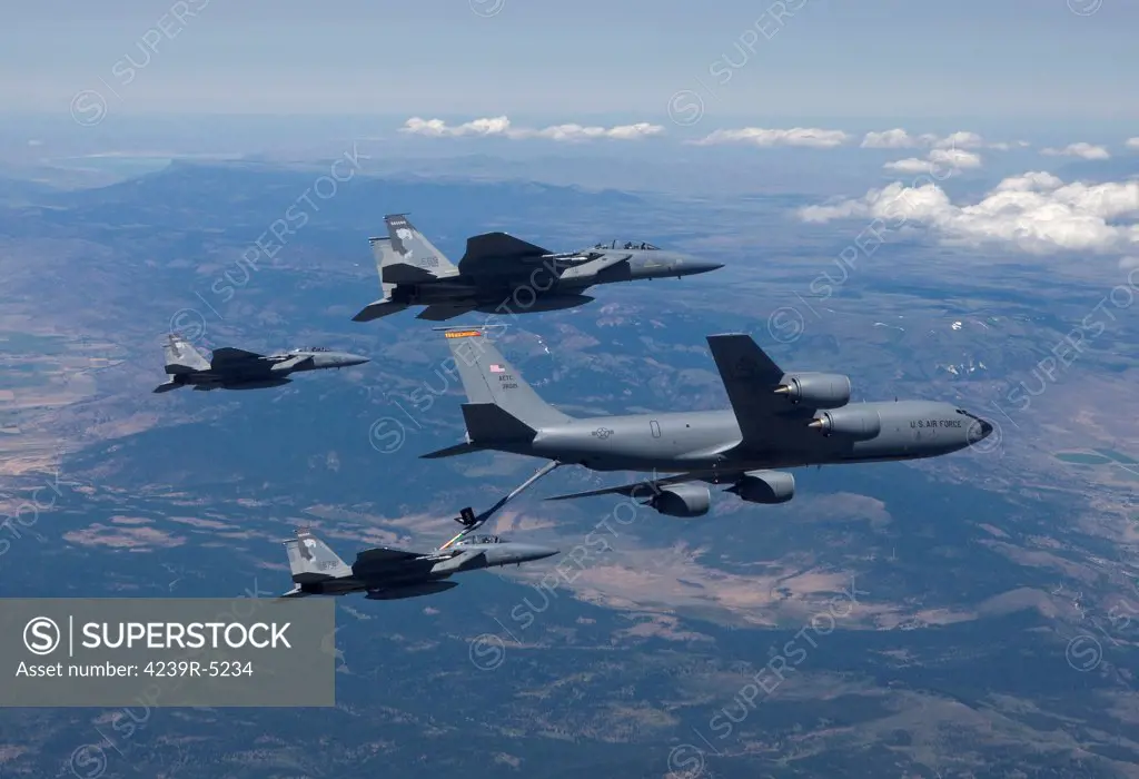A KC-135R Stratotanker refuels three F-15 Eagles during air-to-air refueling training over central Oregon.