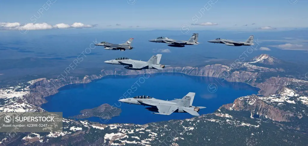 A five ship formation of two F-15 Eagles, two F-18 Super Hornets and an F-16 Fighting Falcon fly over Crater Lake, Oregon, during the Sentry Eagle Excercise.