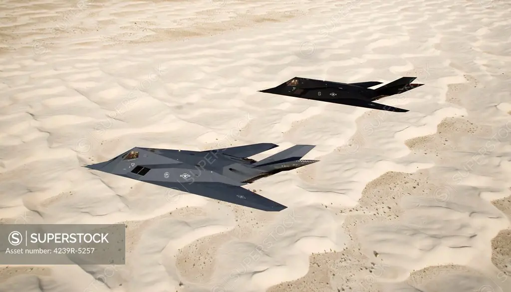 Two F-117 Nighthawk stealth fighters fly on a training sortie out of Holloman Air Force Base, New Mexico, over the White Sands National Monument.