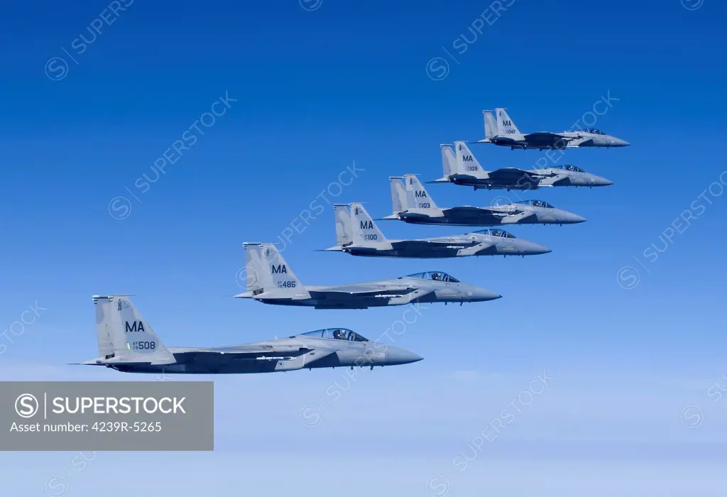 Six F-15 Eagles from the Massachusetts Air National Guard fly in formation high over New England during a training mission.