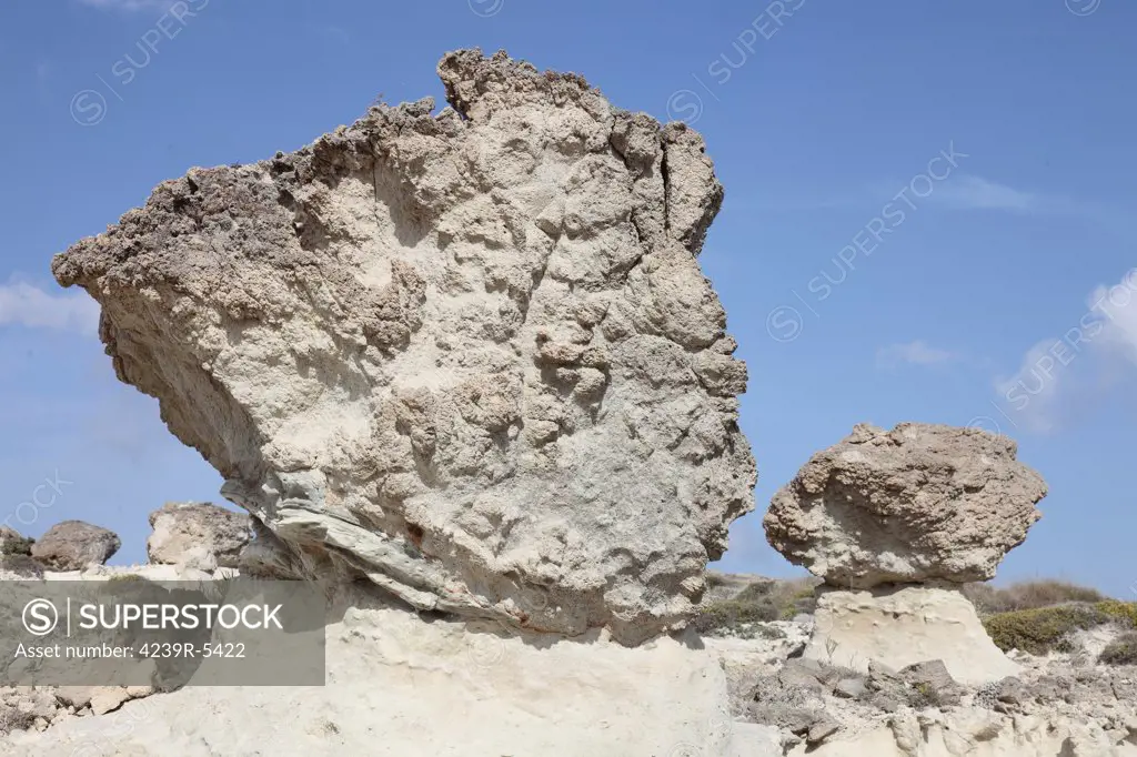 Sarakiniko white tuff formations, Milos, Greece. Emplaced in a submarine environment and subsequently uplifted by volcano-tectonic processes. Image shows mushroom shaped rock formations formed by protection of tuff from weathering by harder rock deposited above.
