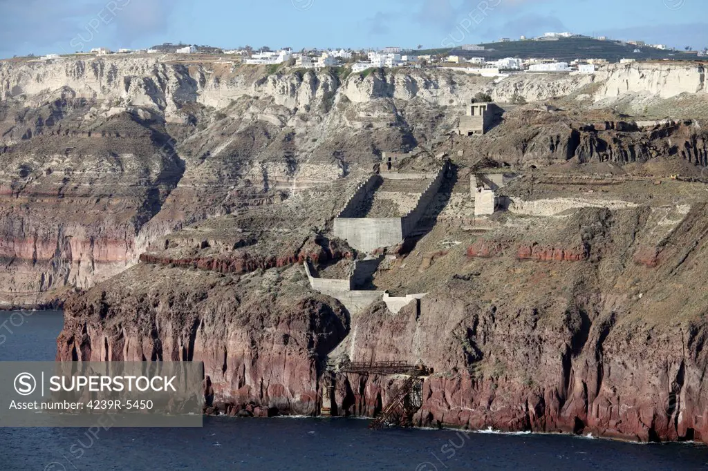 Mavromatis Pumice quarry with pier for loading bulk carriers. Mining of many meter thick tuff deposit from Minoan Eruption occurred at many sites on Santorini (Thera), Greece. Image also shows inner walls of composite caldera.