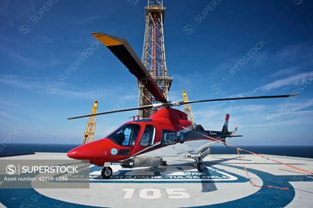 AgustaWestland AW109E utility helicopter on the helipad of an oil rig.