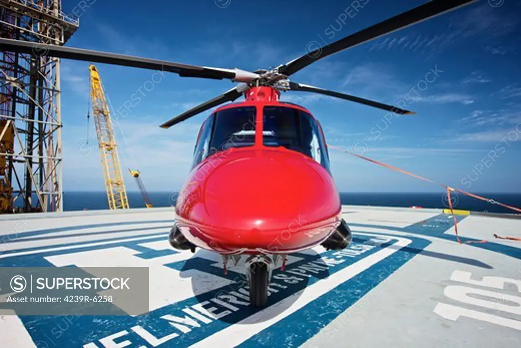AgustaWestland AW109E utility helicopter on the helipad of an oil rig.