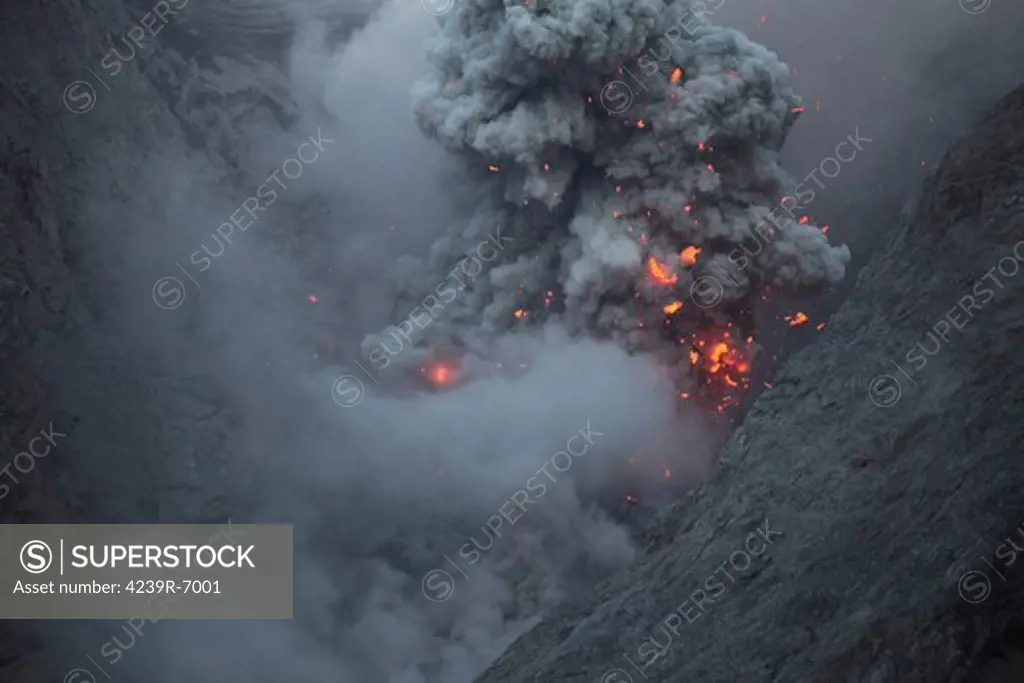 November 28, 2012 - Ash cloud rising during explosive strombolian eruption rising from active crater of Batu Tara volcano, Komba Island, Indonesia. The ash cloud contains volcanic bombs made of glowing lava which are visible as image taken at dusk.