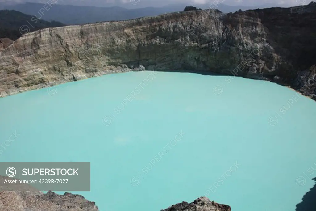 December 3, 2012 -Colourful crater lakes of Kelimutu volcano, Flores Island, Indonesia. Tiwu Nuwa Muri Koo Fai (Lake of Young Men and Maidens) and Tiwu Ata Polo (Bewitched Lake). The lake is highly acidic due to underwater fumarole activity and is turqoise in colour.