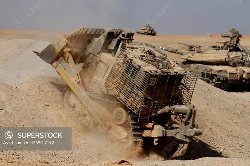 An Israel Defense Force armoured Caterpillar D-9 clearing the way for Mark IV main battle tank during an exercise.