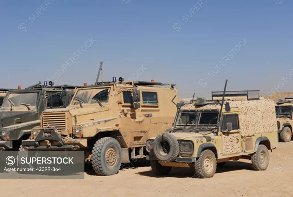 A British Armed Forces Snatch Land Rover patrol vehicle parked next to other military vehicles